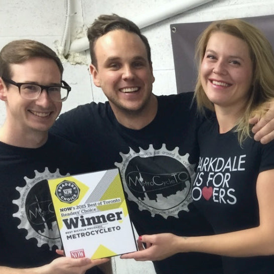 Three people posing with a award in front of a 'MetroCycleTO' banner.