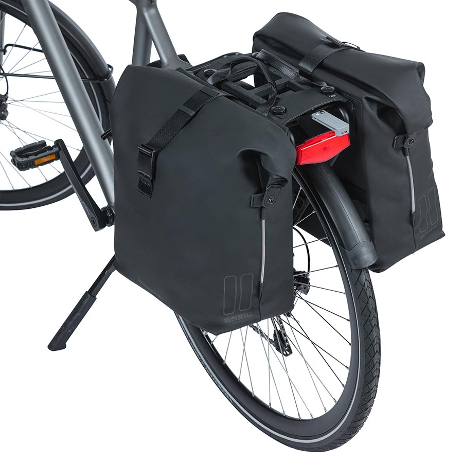 Basil SoHo black panniers mounted on a bicycle, 42L capacity, durable waterproof fabric for commuting and bike touring.