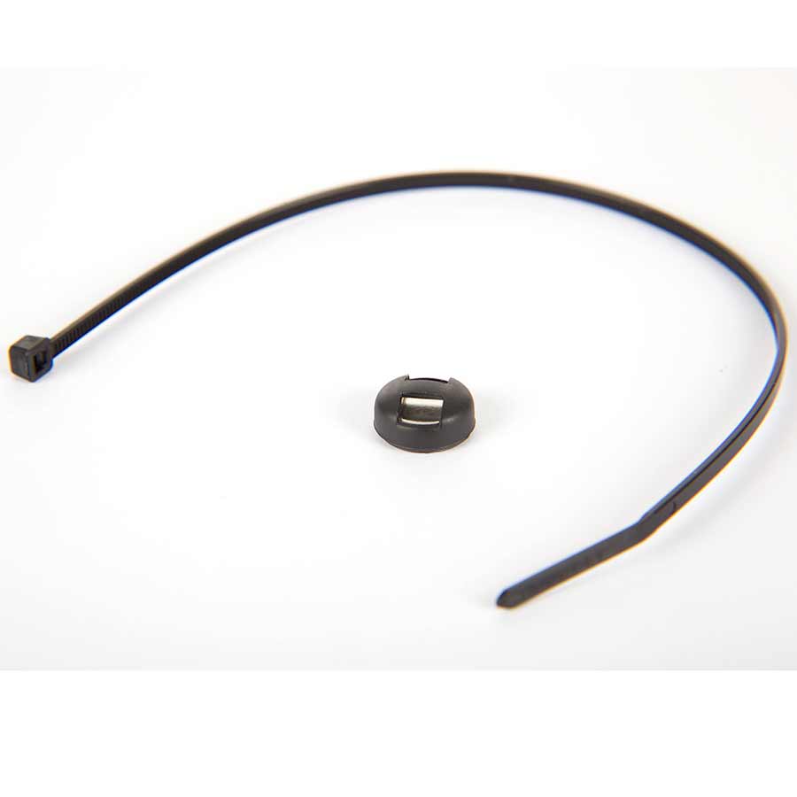 CatEye Cadence Magnet for bicycle computer speed sensors, close-up view of the small round magnet on a bike wheel.