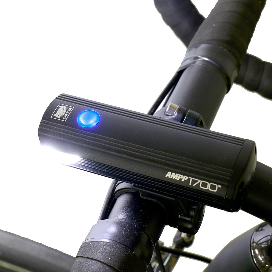 CatEye AMPP 1700 bike light showing its bright LED beam and compact design for high visibility cycling.