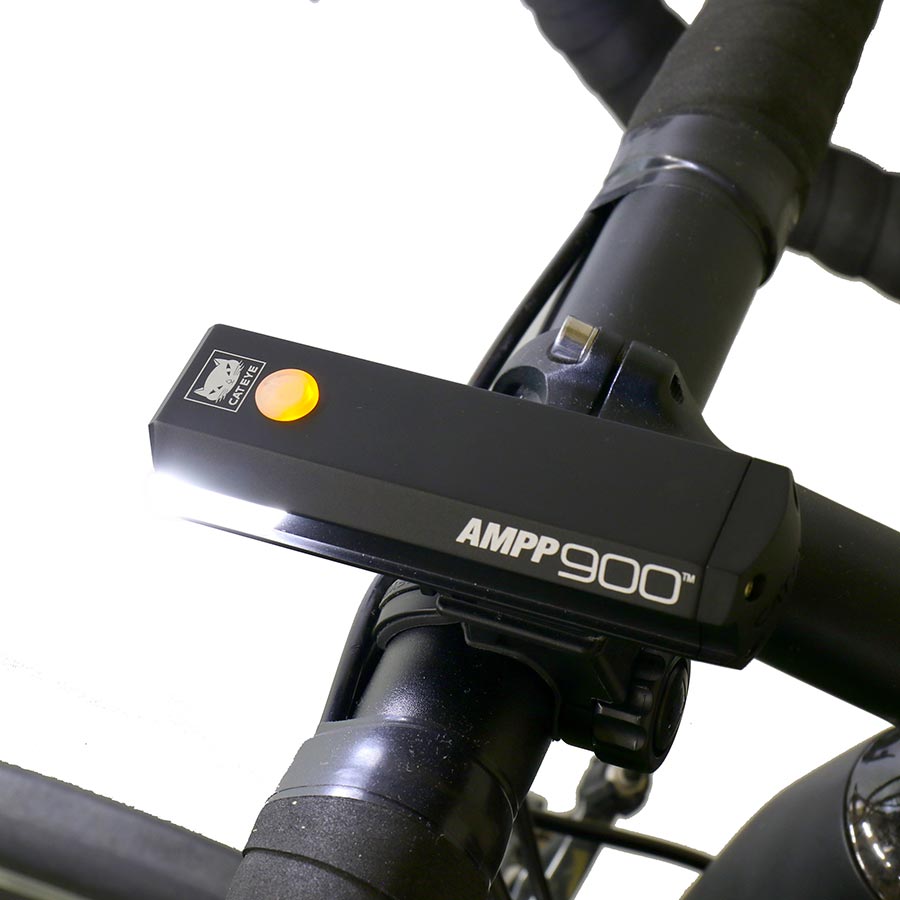 CatEye AMPP900 bike light with bright LED beam, mounted on a bicycle handlebar for enhanced visibility and safety.