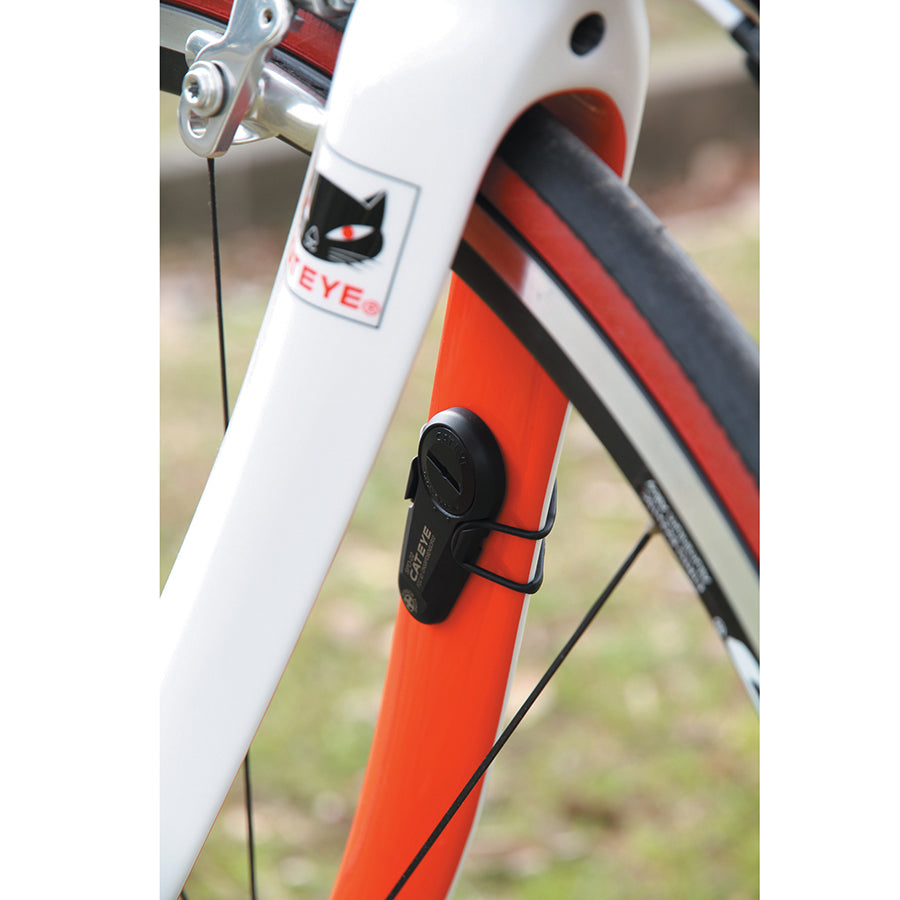 CatEye Strada Slim computer mounted on a road bike, black cycling sensor with sleek, compact design for accurate speed and distance tracking.