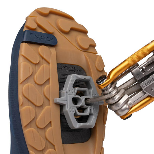 Crankbrothers cleat tool for adjusting and installing bicycle cleats, shown in grey with a compact design for bike maintenance.
