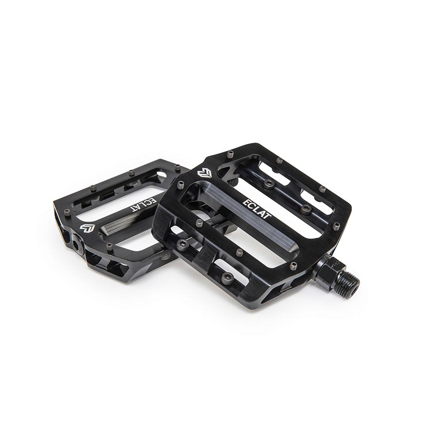 Pair of black Eclat Surge CNC platform pedals showing metal body and textured grip surface for BMX biking.