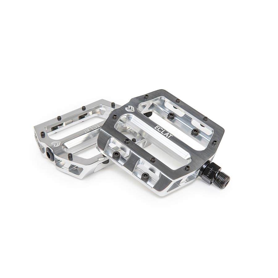 Pair of black Eclat Surge CNC platform pedals with textured surface for BMX biking, shown in a close-up image.