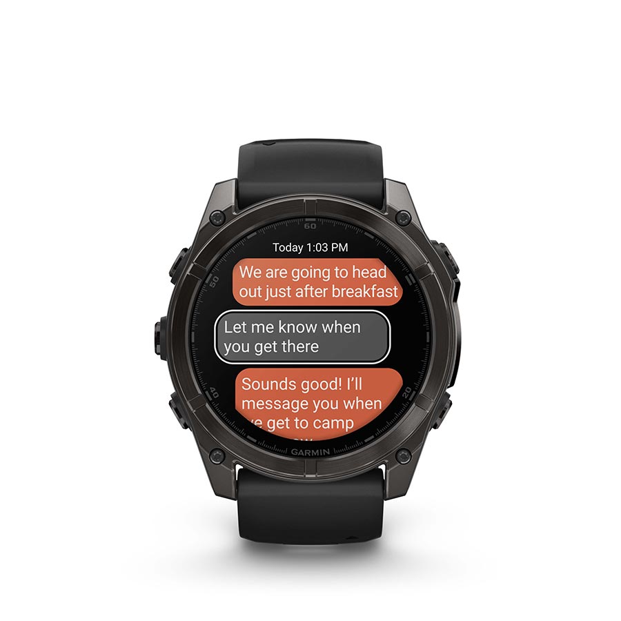Garmin Fenix 8 AMOLED Sapphire 51mm watch with grey silicone wristband on a person's wrist, displaying a black pebble watch face.