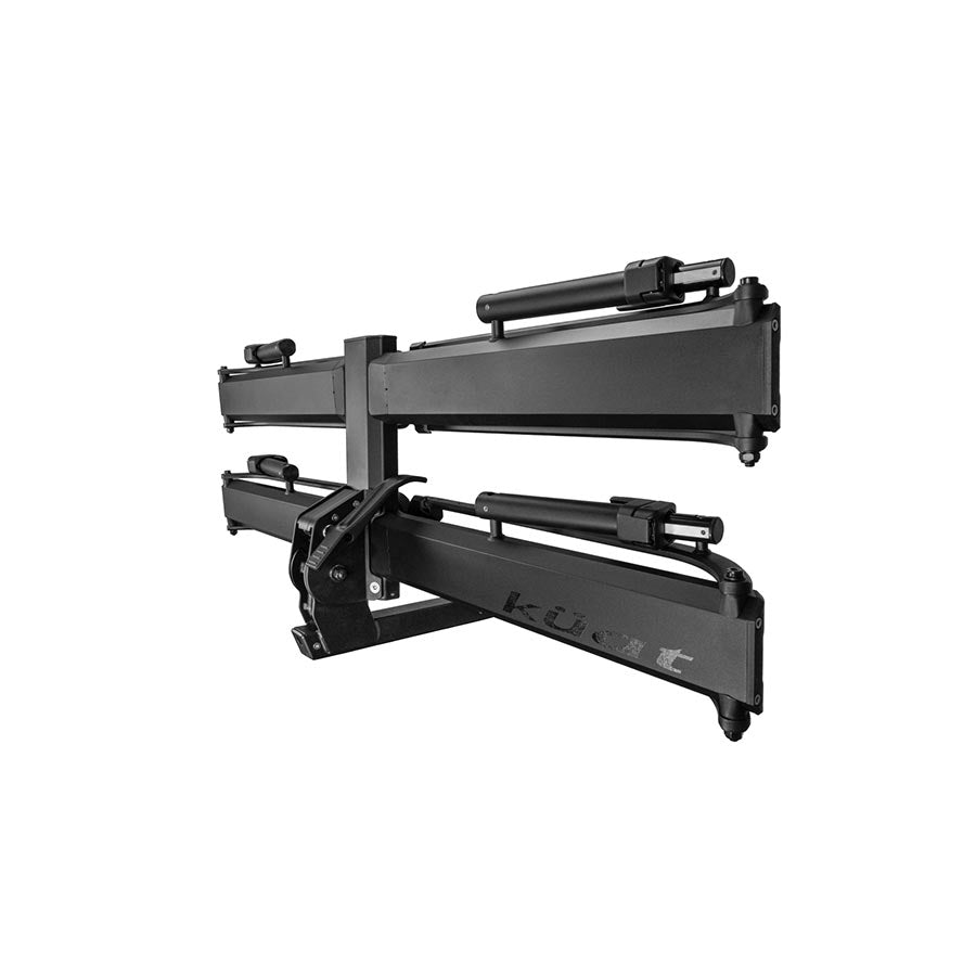 Kuat Piston Pro hitch rack in sandy black holding two bikes, designed for 1.4-inch hitch receivers, outdoor bike transport.