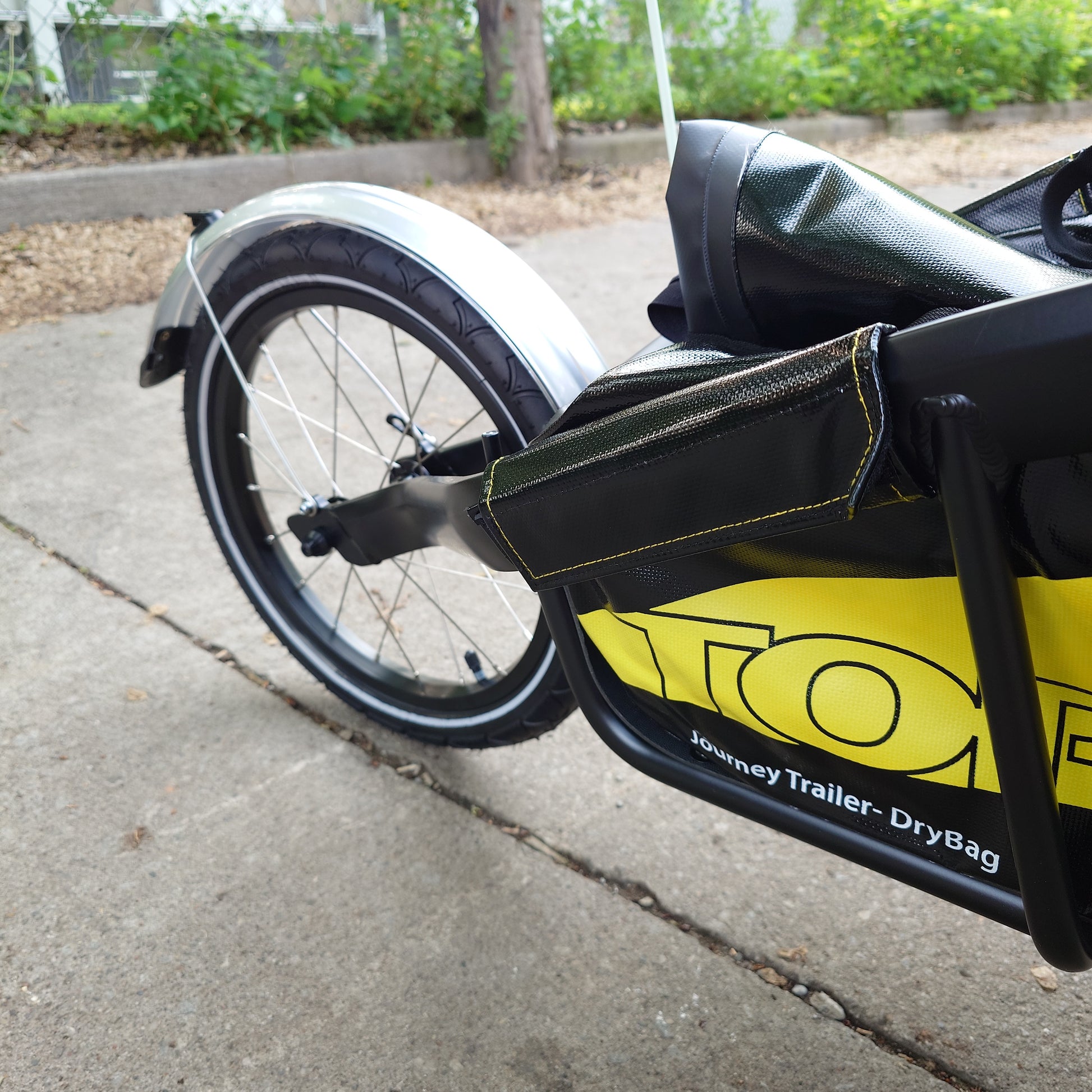 Topeak JOURNEY TX Thru-Axle Trailer attached to a bicycle, designed for bike transport and compatible with specific bike frames.