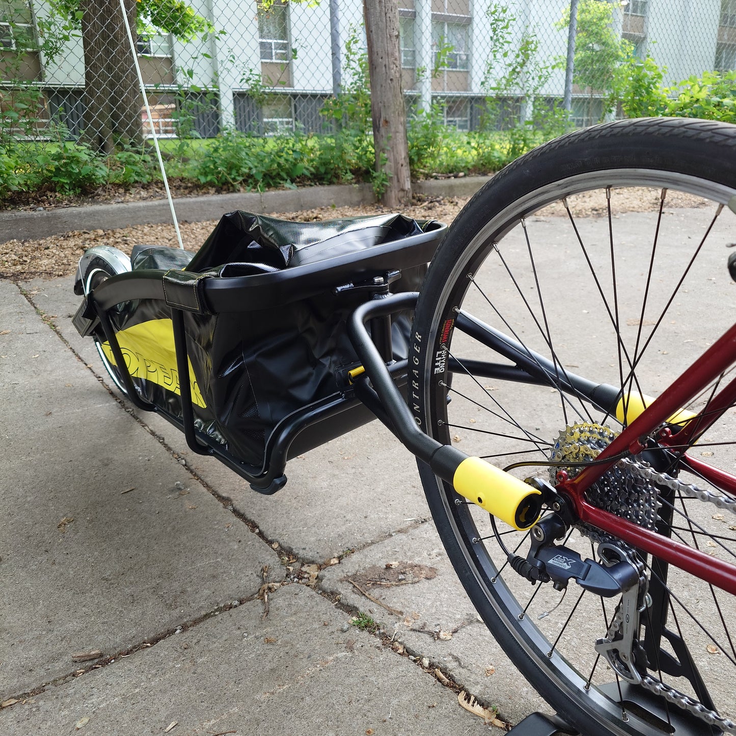 Topeak Journey Q/R compatible trailer attached to a bicycle, designed for carrying cargo on bike tours and commuting.