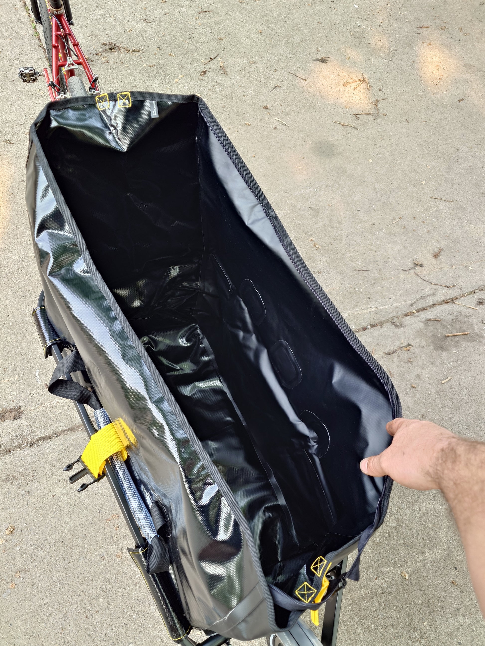 Topeak Journey TX Thru-Axle Trailer attached to a bicycle, showing its compact design and secure mounting system.