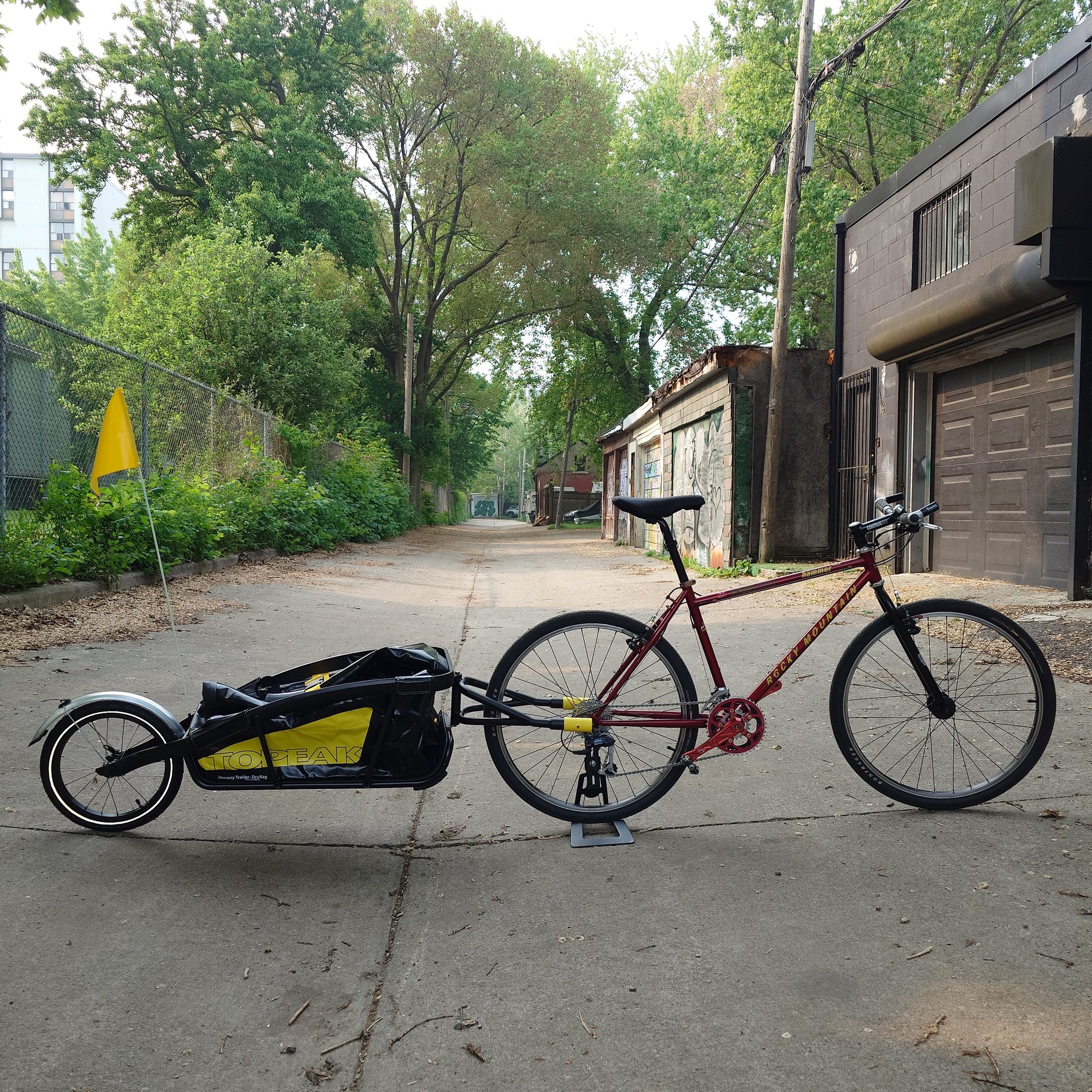Topeak Journey TX Thru-Axle Trailer attached to a bicycle, ready for hauling gear on a bike trail or adventure.